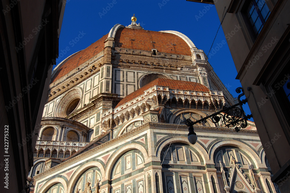 View of Santa Maria del Fiore (St Mary of the Flower) in Florence from a narrow lane, built by italian architect Brunelleschi in the 15th century, a symbol of Renaissance in the world
