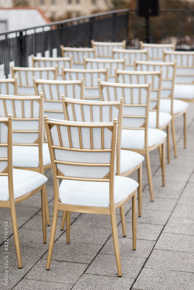 Many white chairs are lined up for guests on the roof of the house to celebrate
