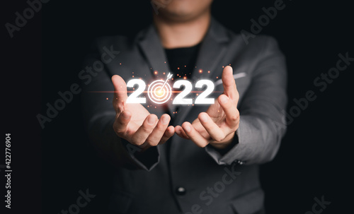 Businessman holding virtual 2022 with target board for setup business objective target for start new year.