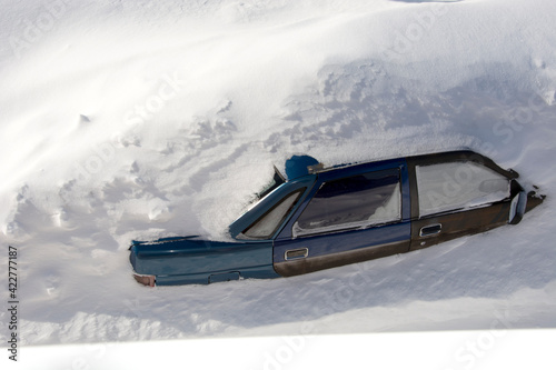 Car in a snowdrift to the very roof, top view. The passenger car was covered with snow. There is a lot of snow outside.