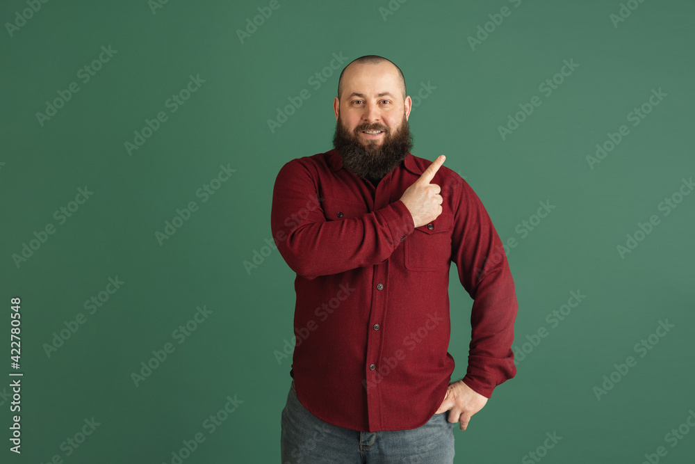 Handsome caucasian man portrait isolated on green studio background with copyspace Handsome caucasian man portrait isolated on green studio background with copyspace