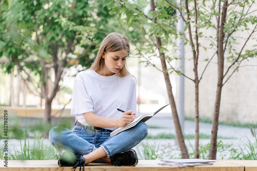 Obraz premium Adult student girl making homework in copybooks