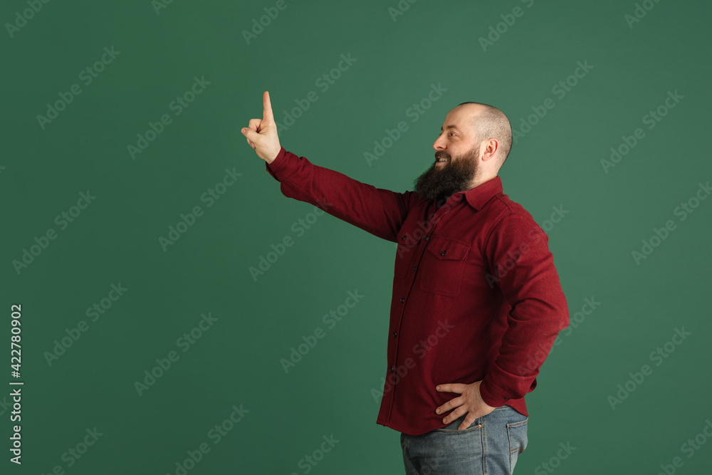 Handsome caucasian man portrait isolated on green studio background with copyspace Handsome caucasian man portrait isolated on green studio background with copyspace