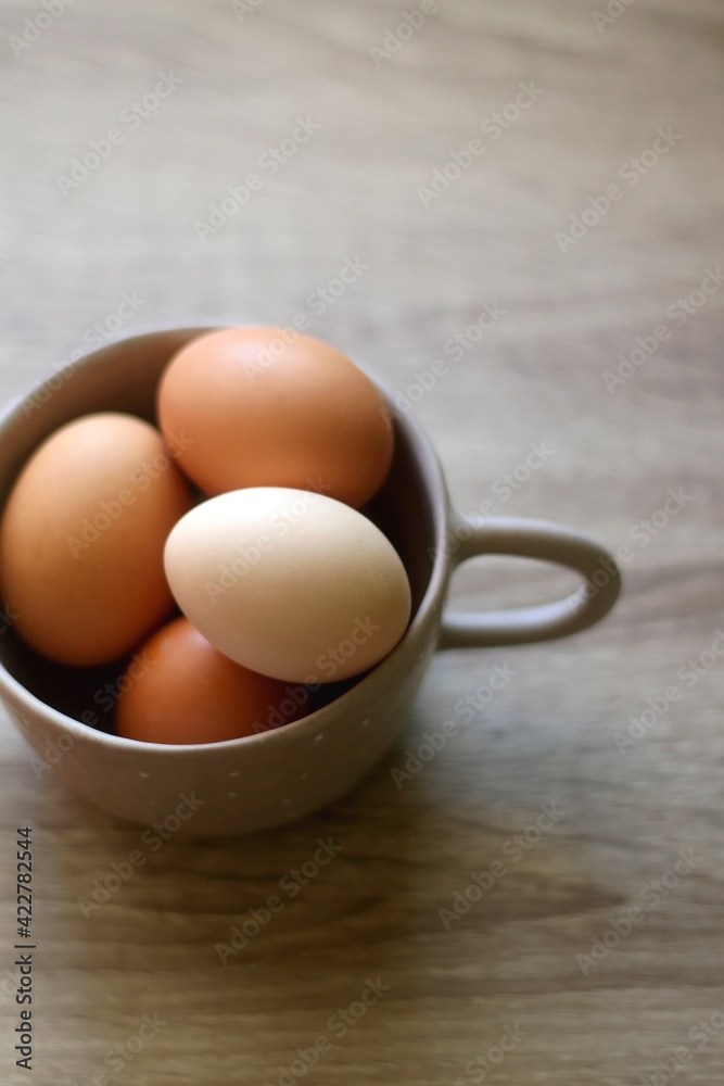 Ceramic bowl filled with fresh free range eggs on wooden table. Selective focus. Ceramic bowl filled with fresh free range eggs on wooden table. Selective focus.