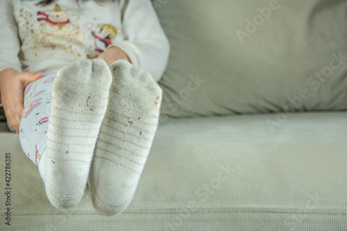 Little girl whose socks are dirty from dirt in the house