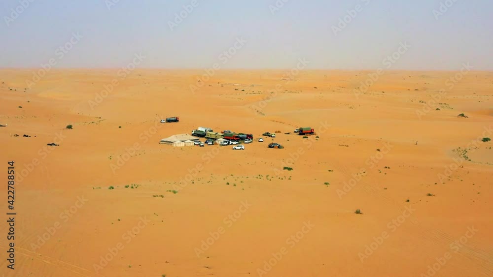 Aerial drone view towards cars at a remote desert camp, sunny day, Saudi Arabia Aerial drone view towards cars at a remote desert camp, sunny day, Saudi Arabia