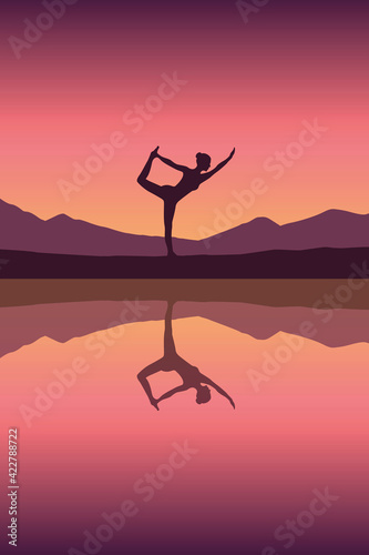 girl makes yoga by the lake at sunset