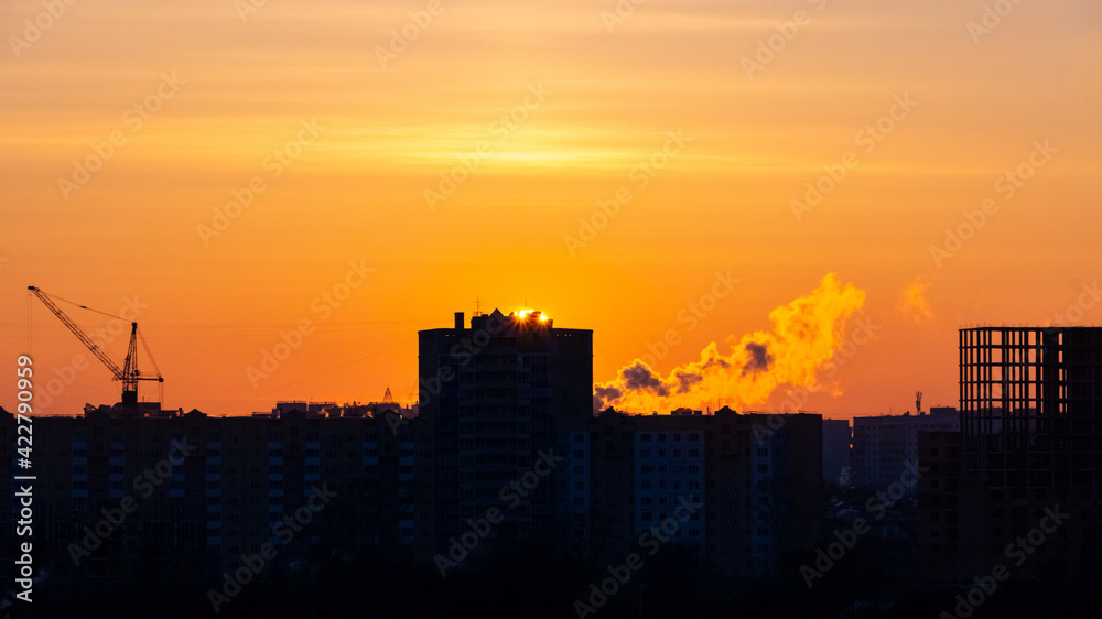 Fototapeta premium sunset over the construction site and the city
