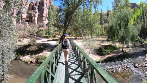 Female tourist walking on the bridge inIhlara valley in Cappadocia, Turkey photo