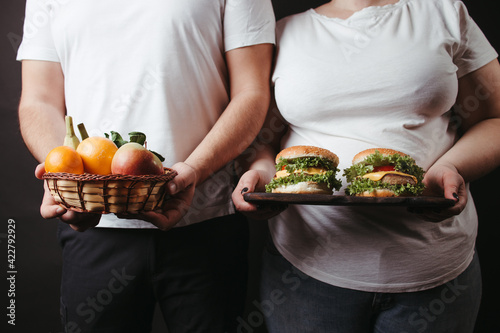 Overweight couple with healthy and unhealthy food