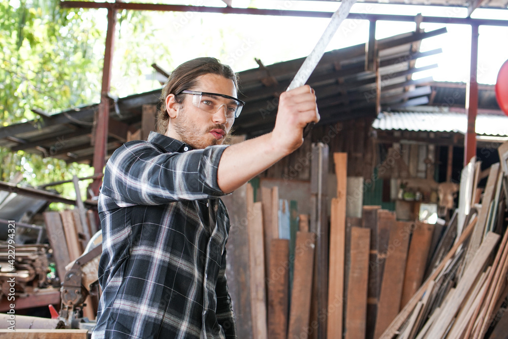 Caucasian male carpenter playing ruler as a gun at Woodstock workshop. Caucasian male carpenter playing ruler as a gun at Woodstock workshop.