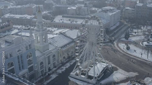 Kiev. Drone video. The big white Ferris wheel and tourists walking in the center of Kontraktova Square in the Podolsk district of Kiev. Winter morning. photo