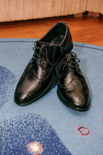 Black classic men's leather shoes stand on the floor