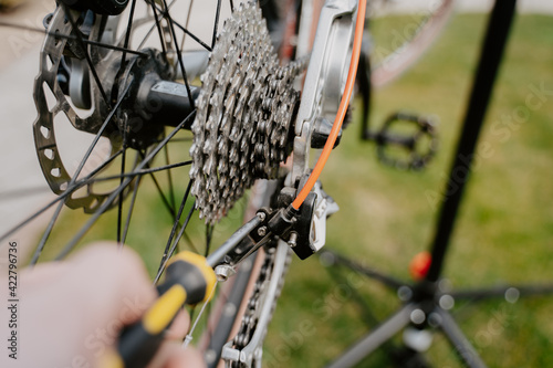 Closeup of bicycle mechanic with a screwdriver repairing bicycle