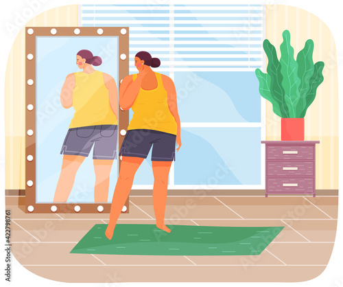 Woman in sportswear looking at reflection in mirror. Unhappy plump girl standing in front of mirror
