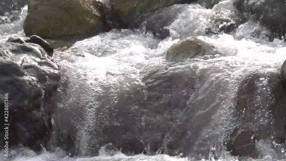 Resounding sound of a stream of water flowing through the stones Resounding sound of a stream of water flowing through the stones