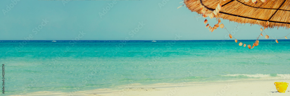 Fototapeta premium Empty tropical beach background with umbrella. Horizon with sky and white sand