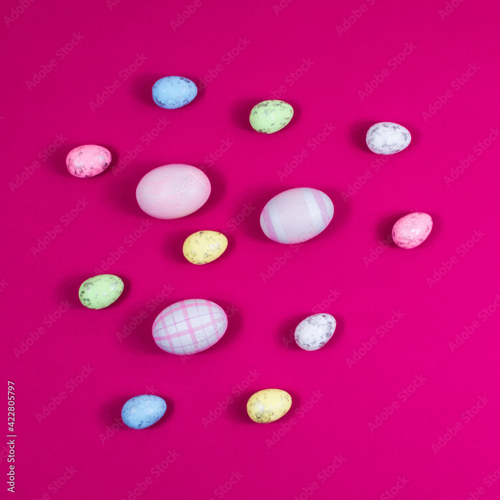 Colorful Easter eggs on a red raspberry background with copy space. The basis for the postcard.