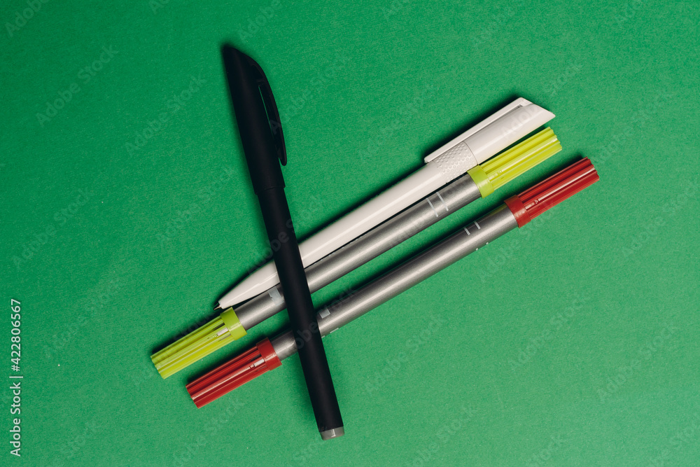 multicolored pens on a green background office supplies work stationery multicolored pens on a green background office supplies work stationery