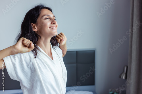 Fotografie Beautiful woman waking up on her bed at bedroom Young Female stretching and smil