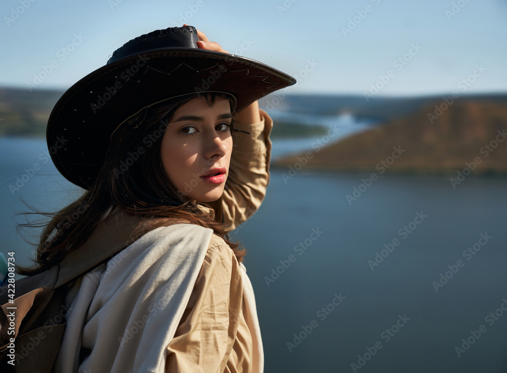 Attractive woman in cowboy hat standing on high hill Attractive woman in cowboy hat standing on high hill