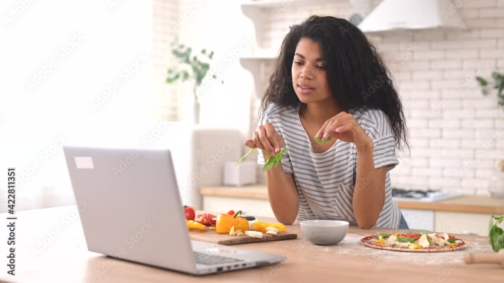 A cute smiling multiethnic girl with curly hair learns how to cook pizza at home, decorate it with greens, prepare healthy food, take care of health, eat a lot of vitamins, dream of becoming a chef A cute smiling multiethnic girl with curly hair learns how to cook pizza at home, decorate it with greens, prepare healthy food, take care of health, eat a lot of vitamins, dream of becoming a chef
