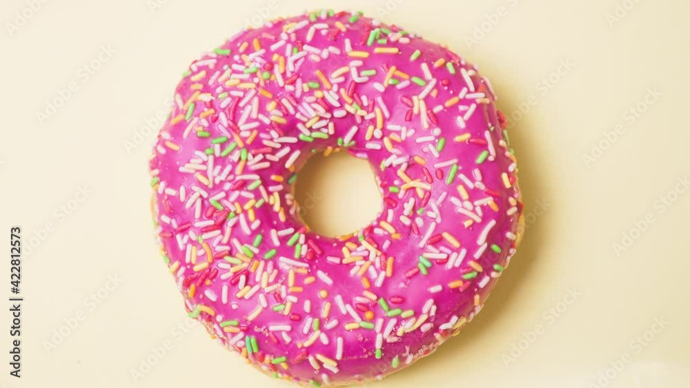 Bright donut in a pink glaze with a multi-colored rainbow sprinkle on a pink background. Sweets and desserts. Minimalistic background with clean place for the inscription. Copy space. Soft focus. Bright donut in a pink glaze with a multi-colored rainbow sprinkle on a pink background. Sweets and desserts. Minimalistic background with clean place for the inscription. Copy space. Soft focus.