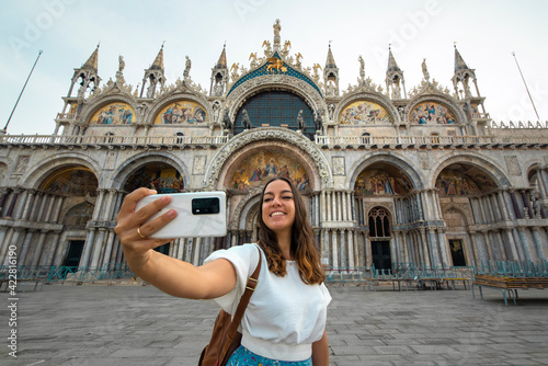 happy young girl taking a selfie while traveling in venice in San Marco Square
