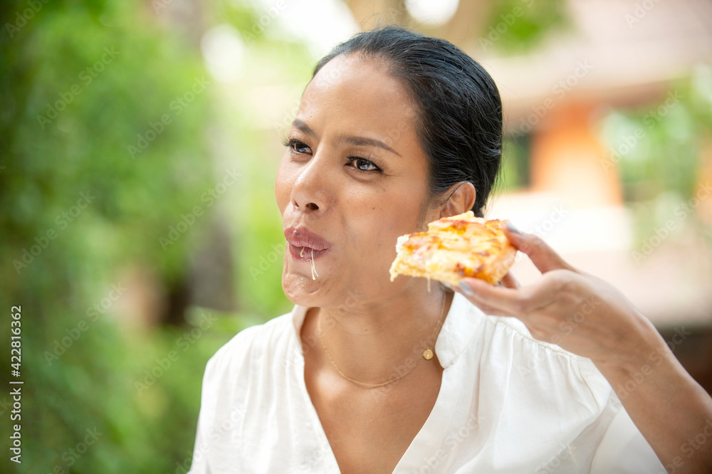 Middle-aged woman is laughing and delicious eating hot pizza.. Middle-aged woman is laughing and delicious eating hot pizza..