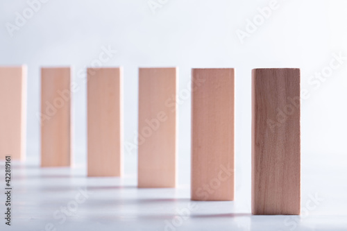 a row of wooden bars standing on the end face on a grey background.Career promotion concept