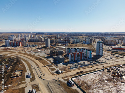 Aerial view of the new urban development. New houses are being built. Nearby are old houses for demolition.
