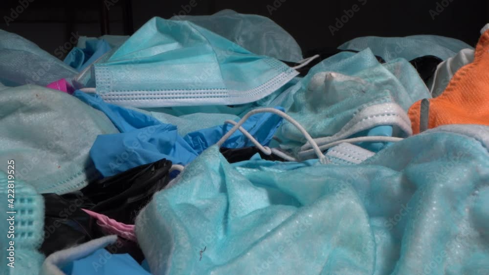 Covid-19 disposable ppe waste. Discarded used old dirty medical protective equipment, mask and gloves in a landfill. Concept of plastic pollution of the world's oceans and environment Covid-19 disposable ppe waste. Discarded used old dirty medical protective equipment, mask and gloves in a landfill. Concept of plastic pollution of the world's oceans and environment