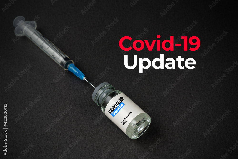 COVID-19 UPDATE text with a bottle of vaccine and syringe on black background. Covid-19 or Coronavirus Concept. COVID-19 UPDATE text with a bottle of vaccine and syringe on black background. Covid-19 or Coronavirus Concept.