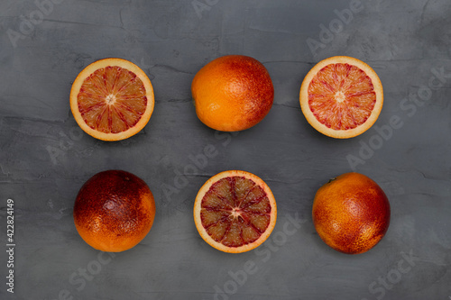 Blood orange on a table. Juicy red fruit texture close up. Gray background with copy space. Healthy eating concept.