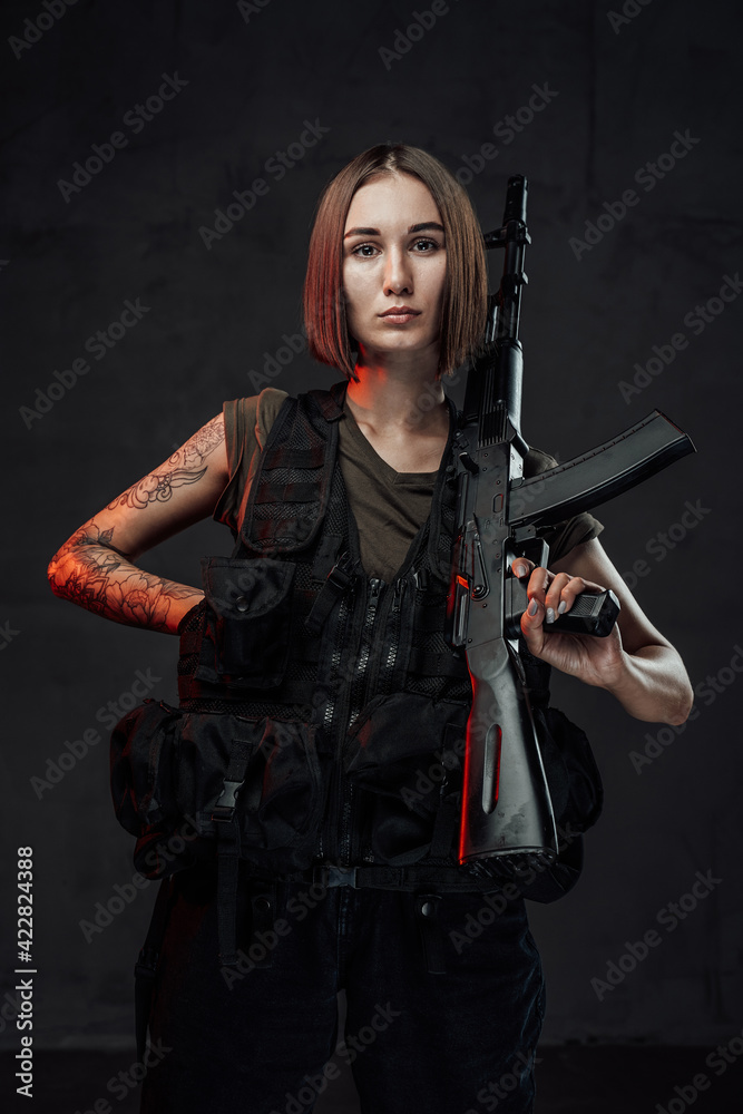 Fototapeta premium Armed with rifle attractive woman in dark background