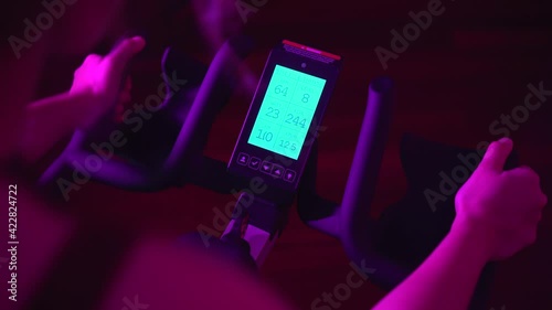 Young girl setting up bike display while doing night spinning session at home or gym