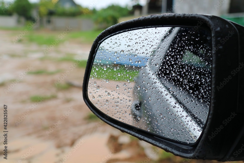 Rain drop on the wing mirror of the car in the raining day. Selective focus. Transportation and nature concept. Rain drop on the wing mirror of the car in the raining day. Selective focus. Transportation and nature concept.