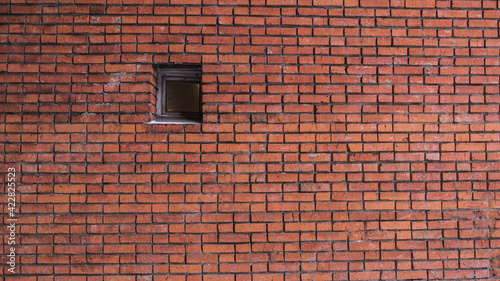 White snow is falling on the background of a brick wall with windows