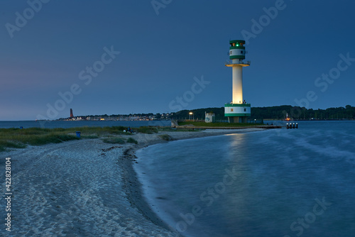Der Leuchtturm am Falckensteiner Strand in der blauen Stunde. Im Hintergrund Labvoe und das Marineehrenmal
