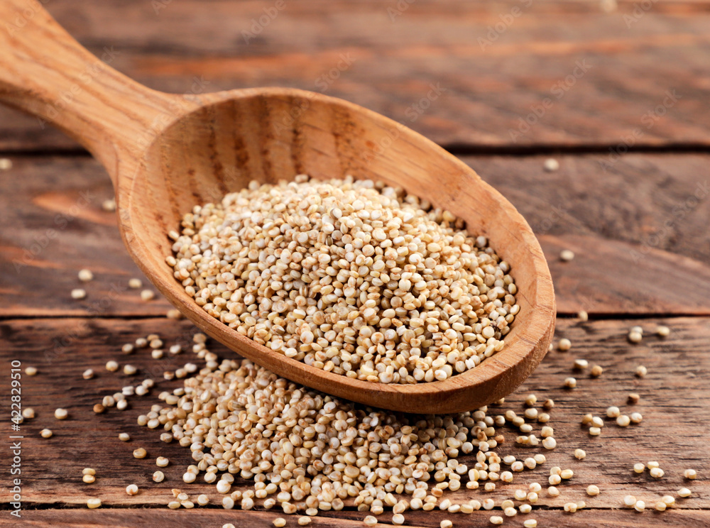 Quinoa in a wooden spoon on a wooden background Quinoa in a wooden spoon on a wooden background