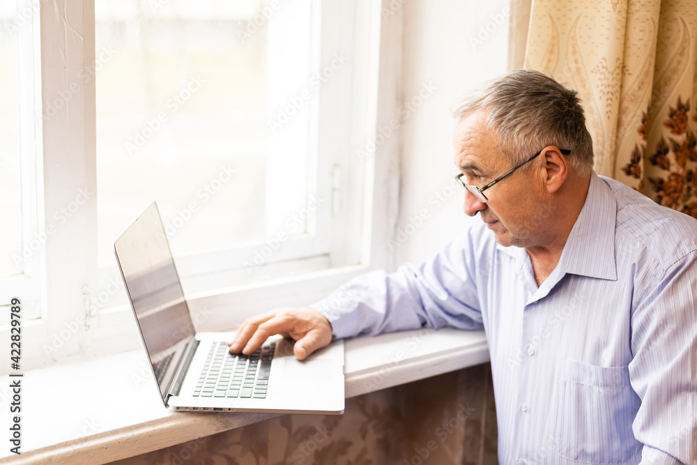 Senior working on a laptop at home Senior working on a laptop at home
