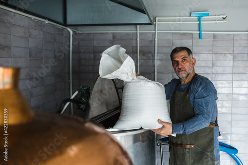 middle aged man working in mini craft brewery