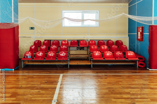colored stands for fans in an indoor stadium. seats in the sports hall for competitions. empty bench of reserve players