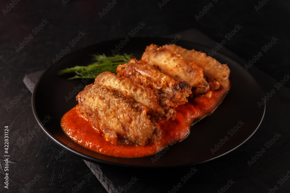 Buffolo wings close-up with tomato sauce and tomatoes Buffolo wings close-up with tomato sauce and tomatoes
