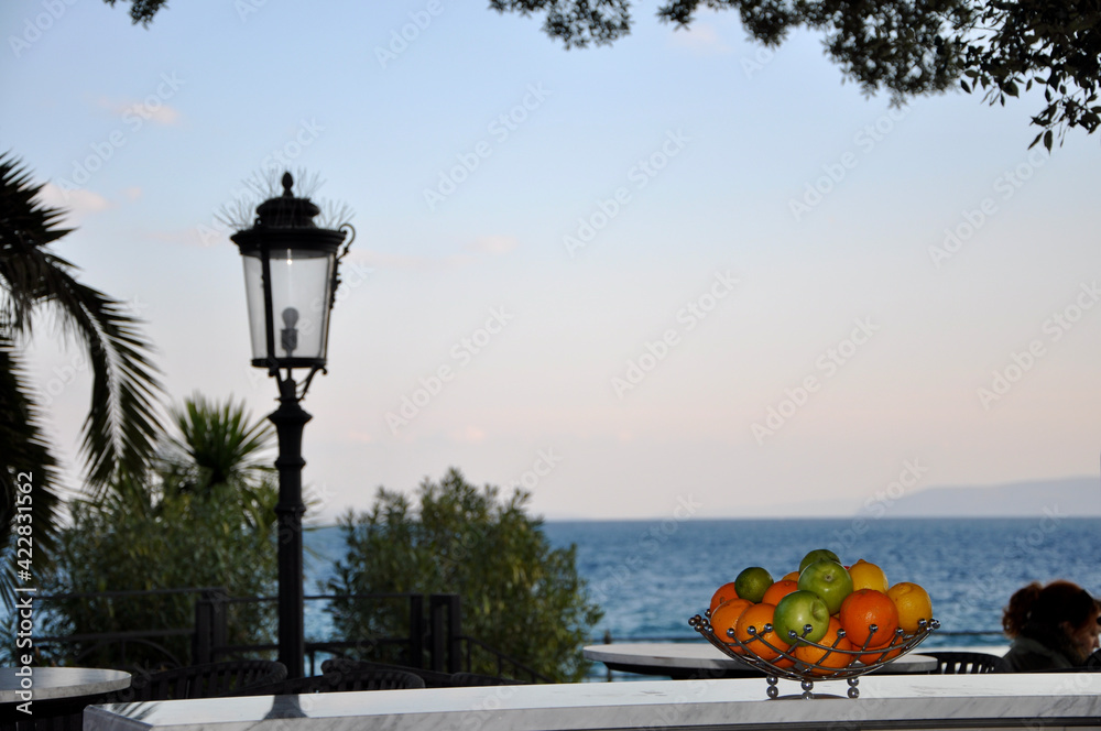 View from hotel room luxury and elegant mediterranean terrace with fruit bawl in morning sun.Lantern and fruit bowl on the balcony overlooking the sea.