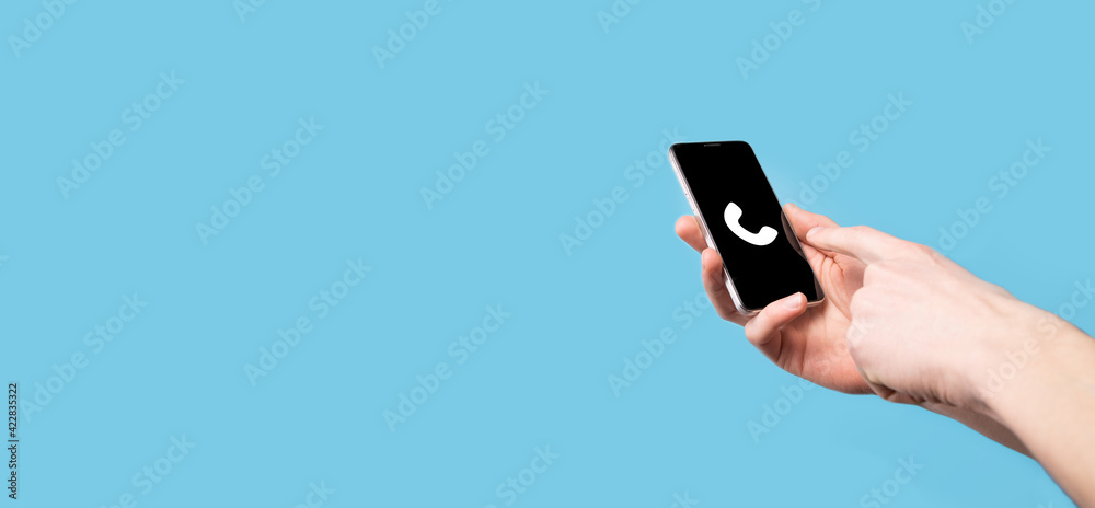 Male hand holding smart mobile phone with phone icon.Call Now Business Communication Support Center Customer Service Technology Concept. Male hand holding smart mobile phone with phone icon.Call Now Business Communication Support Center Customer Service Technology Concept.