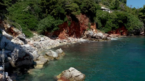 Aerial drone views over a rocky coastline, crystal clear Aegean sea waters, touristic beaches and lots of greenery in Skopelos island, Greece. A typical view of many similar Greek islands.