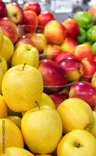 Yellow  red  green apples are sold in the market  blurred background  vertical image.