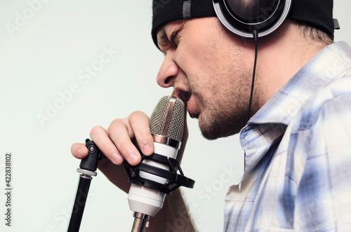 voice recording, a man sings into a condenser microphone