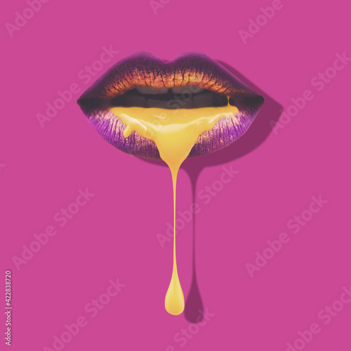 Golden liquid dripping from sexy metalic purple lips on beautiful model girl's mouth. Gold metallic skin make-up. Minimal concept.